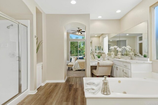 bathroom featuring plus walk in shower, wood-type flooring, vanity, and ceiling fan