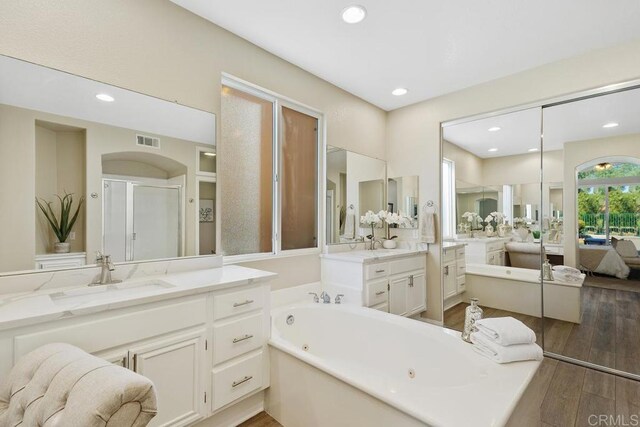 bathroom with separate shower and tub, hardwood / wood-style floors, and vanity