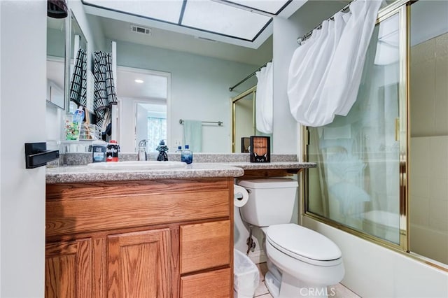 full bathroom featuring tile patterned flooring, vanity, toilet, and enclosed tub / shower combo