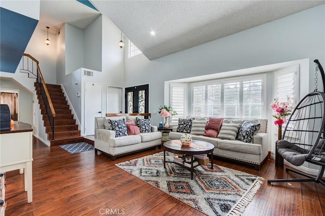 living room with dark hardwood / wood-style floors, a textured ceiling, and high vaulted ceiling