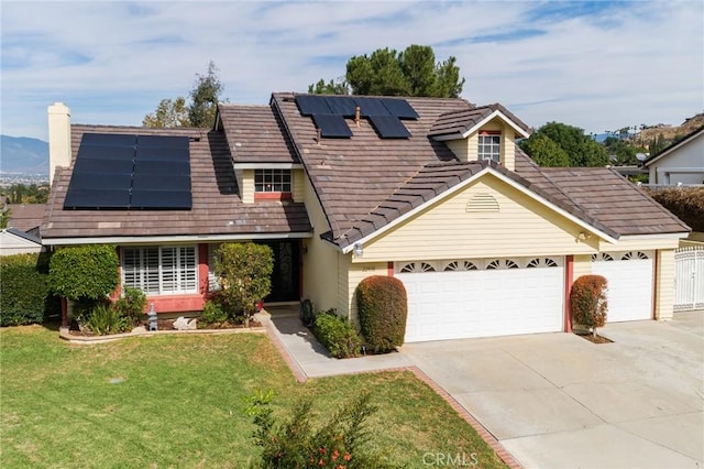 view of front of house with solar panels, a front yard, and a garage