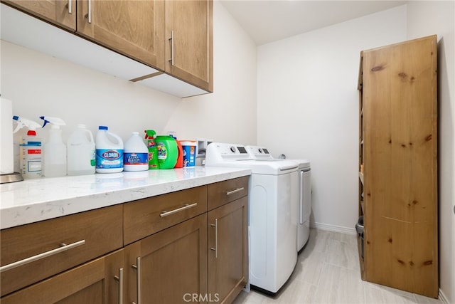 washroom with washer and dryer and cabinets