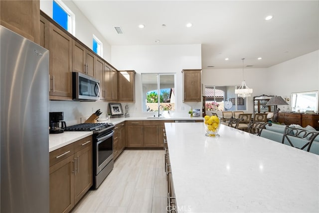 kitchen with sink, stainless steel appliances, and hanging light fixtures