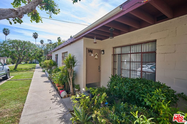 view of exterior entry with a lawn