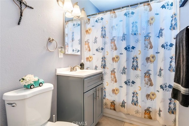 bathroom featuring toilet, vanity, and tile patterned flooring