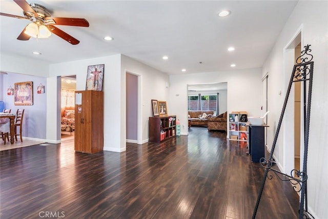 living room featuring dark wood-type flooring and ceiling fan