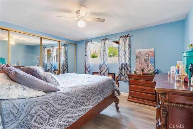 bedroom featuring light wood-type flooring, a closet, and ceiling fan