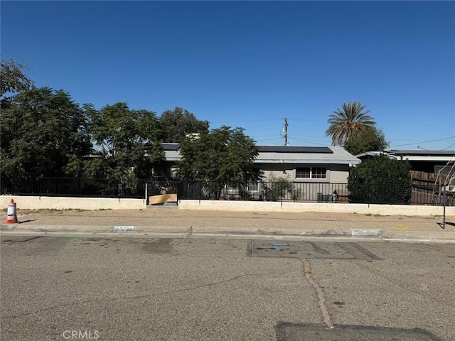 25626 Anderson Ave, Barstow, CA 92311 - obstructed view of property featuring a fenced front yard and roof mounted solar panels
