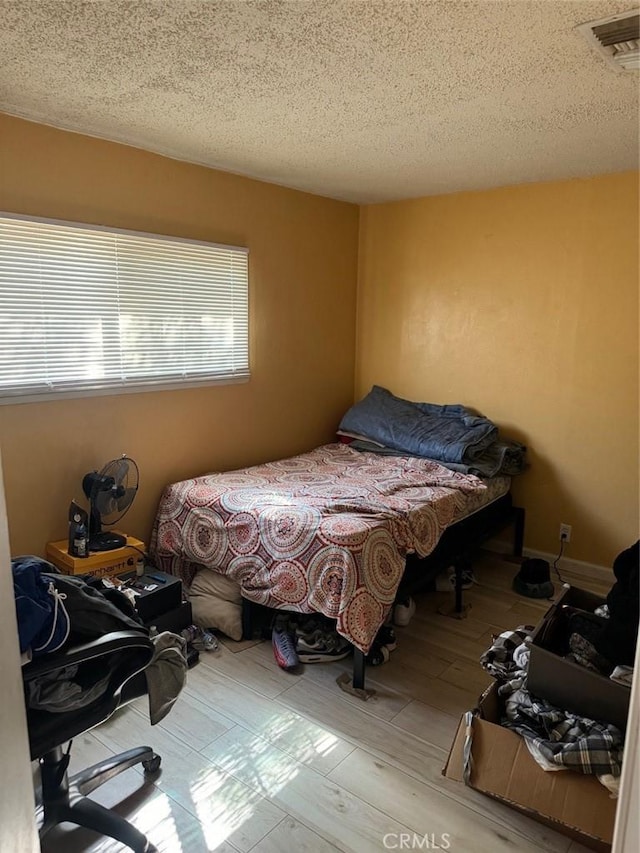 25626 Anderson Ave, Barstow, CA 92311 - bedroom featuring visible vents, a textured ceiling, and wood finished floors
