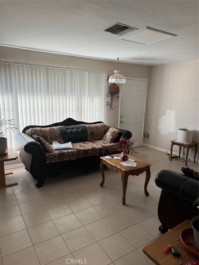 living room with a textured ceiling and light tile patterned floors