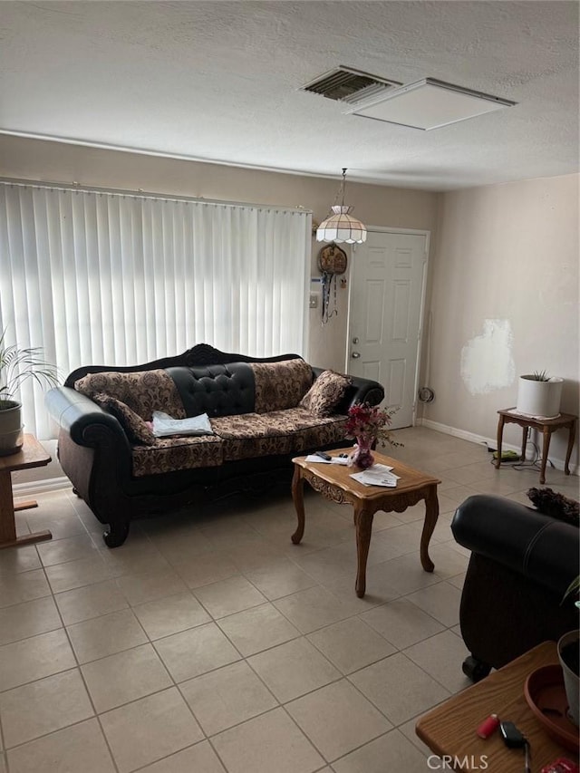 25626 Anderson Ave, Barstow, CA 92311 - living room with visible vents, baseboards, a textured ceiling, and light tile patterned floors