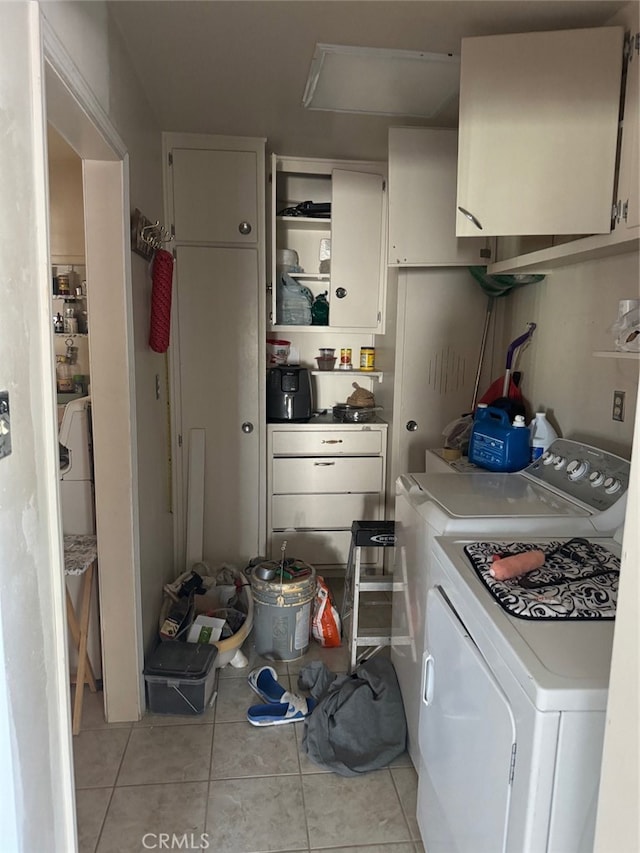 interior space featuring light tile patterned floors, cabinets, and washing machine and clothes dryer