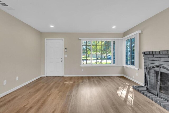 unfurnished living room with a fireplace and light hardwood / wood-style flooring