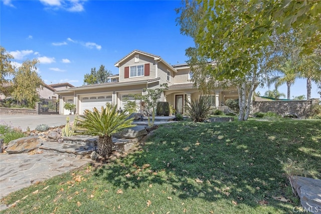 view of front of house featuring a porch, fence, a garage, driveway, and a front lawn