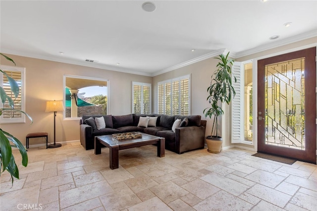 living room featuring ornamental molding, baseboards, and stone tile floors