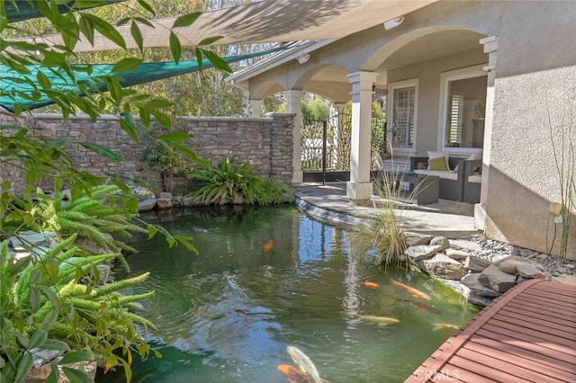 exterior space featuring a small pond and a patio