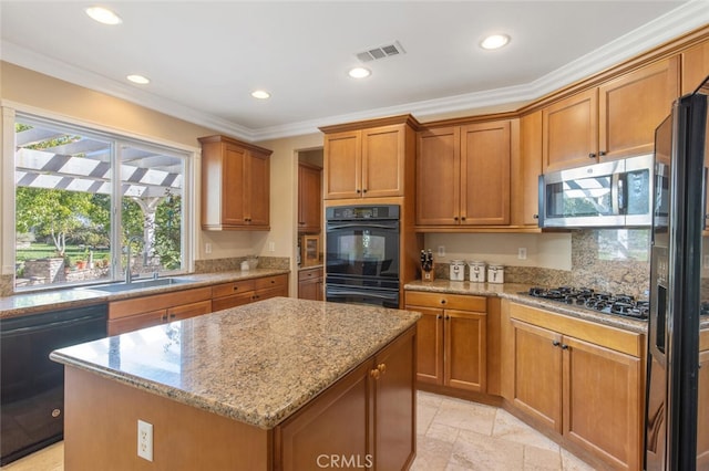 kitchen featuring sink, a center island, light stone counters, black appliances, and ornamental molding