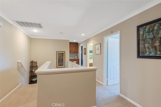 corridor with baseboards, visible vents, light colored carpet, crown molding, and an upstairs landing