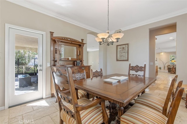 dining area featuring ornamental molding and an inviting chandelier