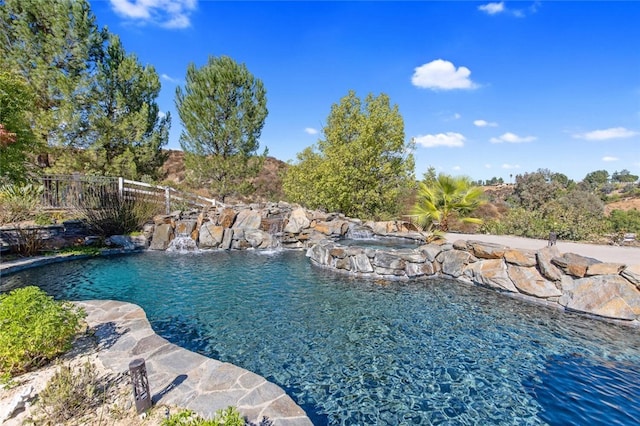 view of swimming pool with pool water feature