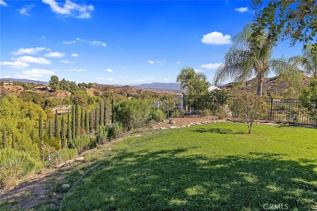 view of yard featuring fence and a mountain view