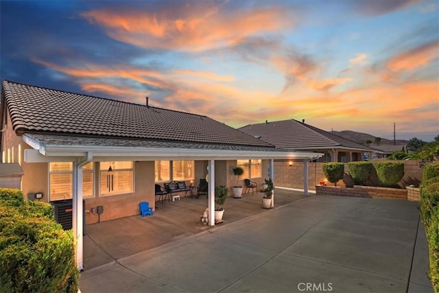 back house at dusk with a patio