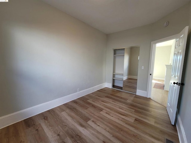 unfurnished bedroom featuring a closet and light wood-type flooring