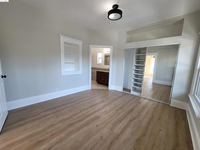 unfurnished bedroom featuring light wood-type flooring and a closet