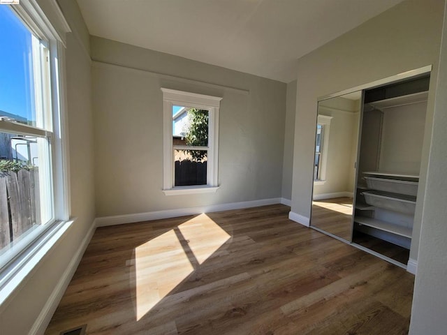 unfurnished bedroom with dark hardwood / wood-style floors and a closet