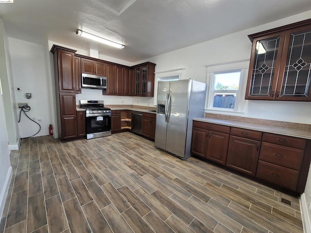 kitchen with dark brown cabinets, dark hardwood / wood-style flooring, a textured ceiling, and appliances with stainless steel finishes