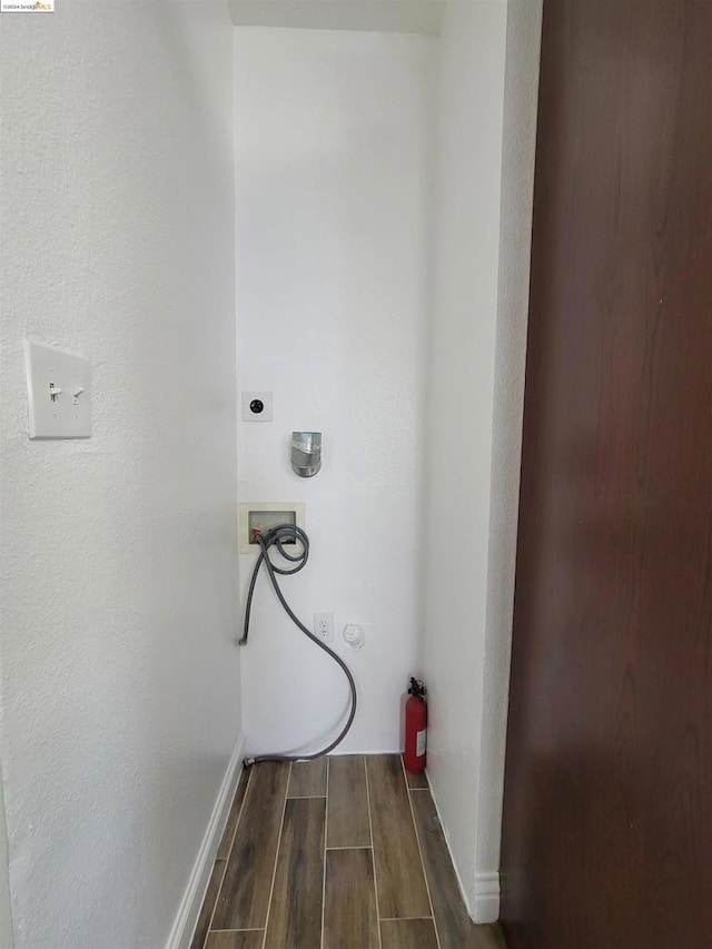 clothes washing area with hookup for an electric dryer, hookup for a washing machine, and dark hardwood / wood-style flooring