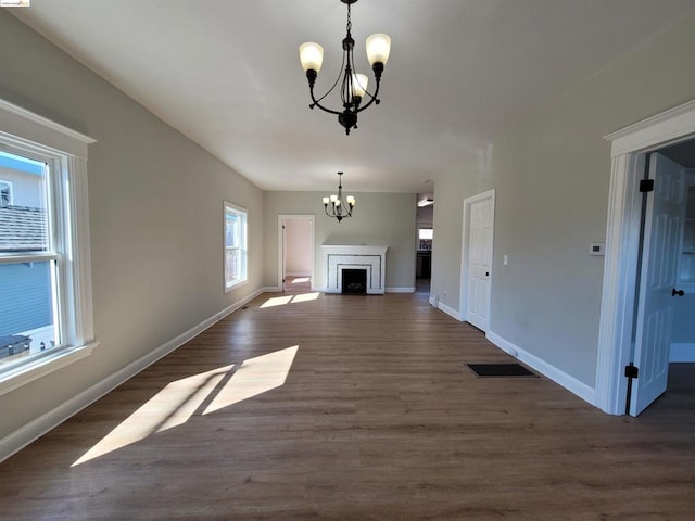 unfurnished living room with dark hardwood / wood-style floors and a notable chandelier