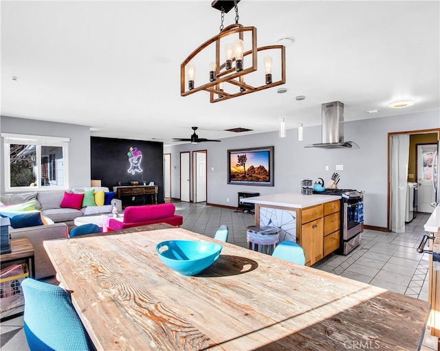 tiled dining room featuring independent washer and dryer and ceiling fan with notable chandelier