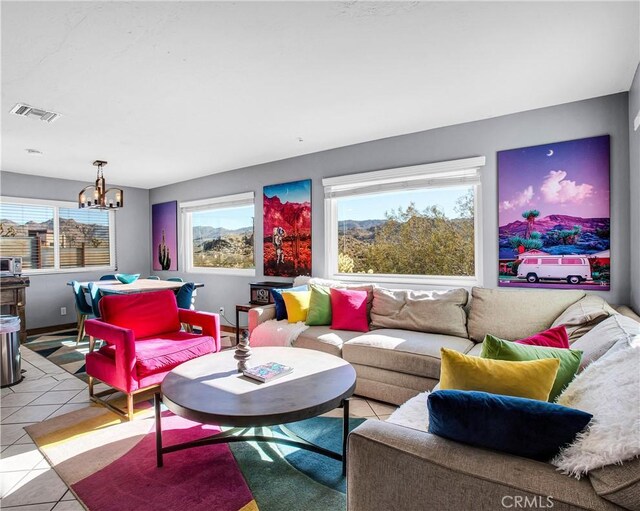 living area with light tile patterned floors, a chandelier, and visible vents