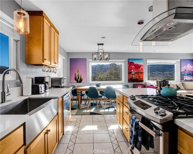 kitchen featuring stainless steel range with gas stovetop, a sink, light tile patterned floors, light countertops, and extractor fan