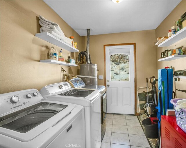 clothes washing area with laundry area, light tile patterned floors, washing machine and dryer, and gas water heater