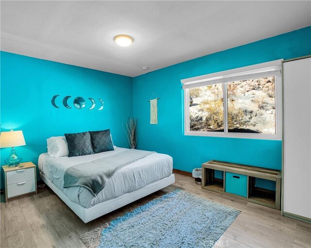 bedroom with baseboards and wood finished floors