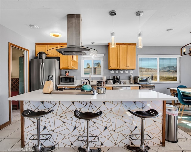 kitchen featuring a kitchen island, island range hood, a breakfast bar, stainless steel appliances, and light tile patterned floors