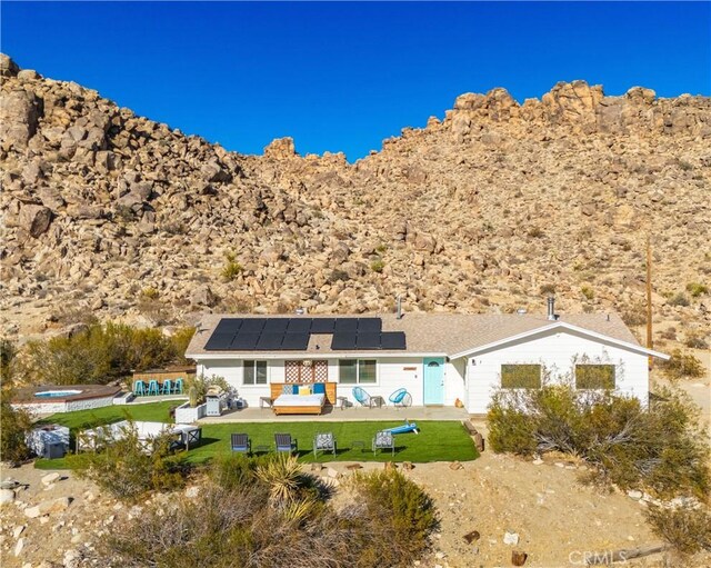 back of property with a yard, solar panels, and a patio area