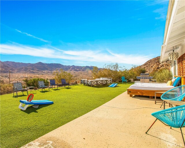 view of community with a patio area, a mountain view, and a lawn