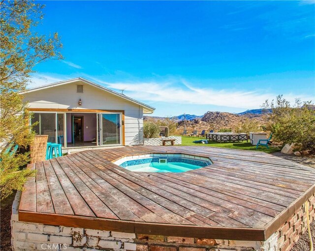 view of pool featuring a sunroom, a deck with mountain view, and hot tub deck surround