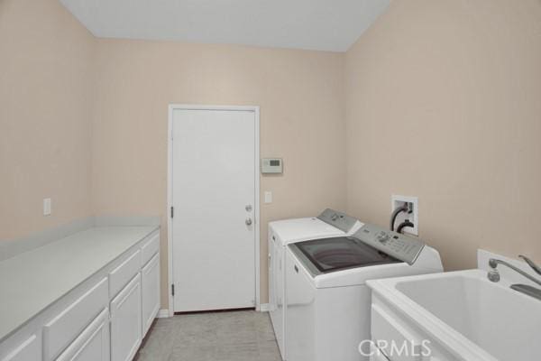 washroom featuring cabinets, independent washer and dryer, and sink