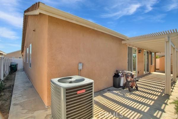 exterior space with a patio, a pergola, and central AC