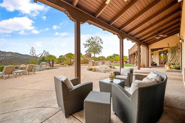 view of patio / terrace with an outdoor hangout area, a mountain view, and ceiling fan