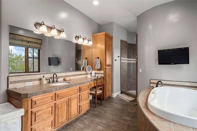 bathroom featuring vanity, separate shower and tub, and hardwood / wood-style flooring