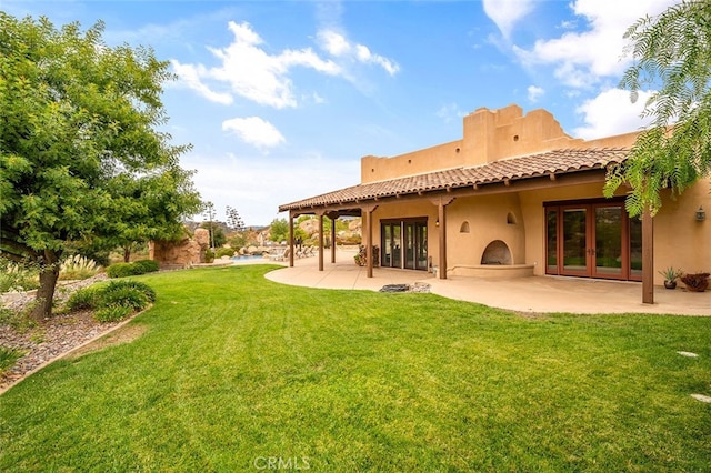 back of property featuring a patio area, french doors, and a yard