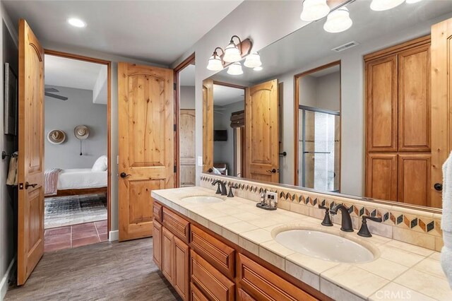 bathroom with vanity, walk in shower, and hardwood / wood-style floors