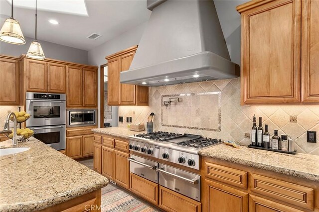 kitchen with premium range hood, stainless steel appliances, pendant lighting, and backsplash