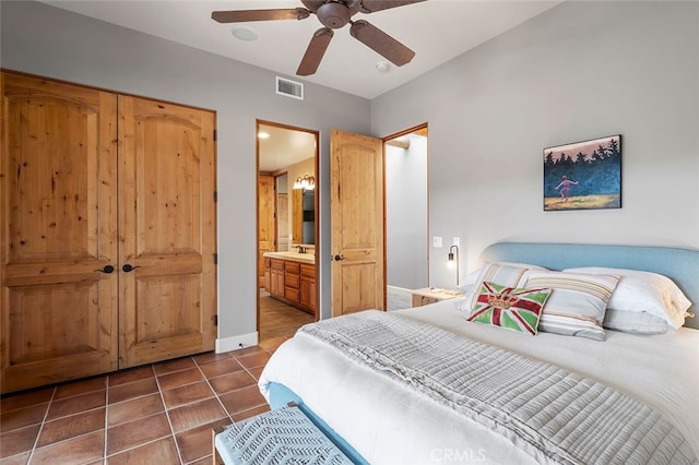 tiled bedroom featuring connected bathroom, sink, and ceiling fan