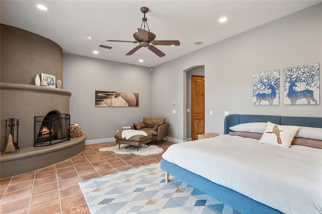 tiled bedroom with a fireplace and ceiling fan